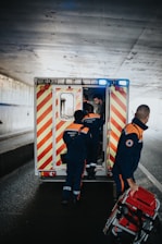 a couple of men standing next to an ambulance