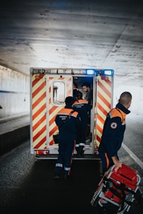 a couple of men standing next to an ambulance