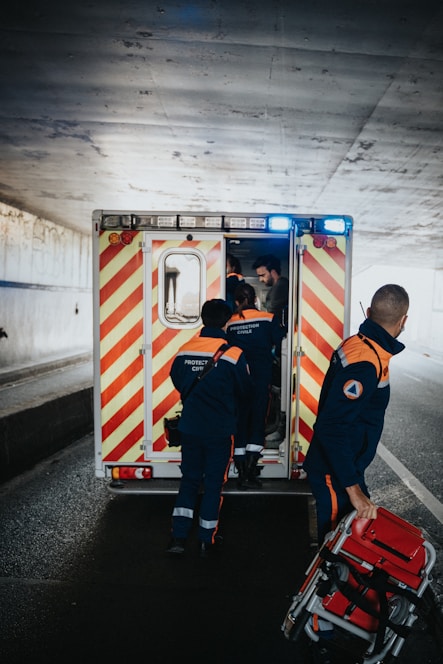 a couple of men standing next to an ambulance