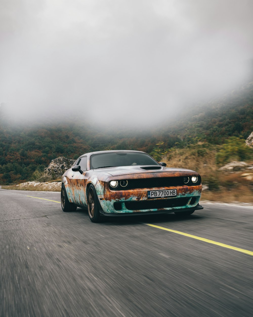 a car driving down a road with a sky background