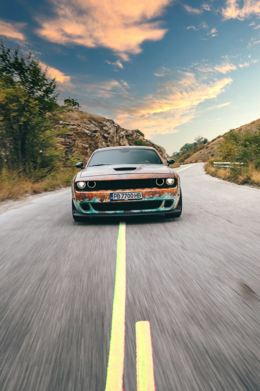 a car driving down a road with a sky background