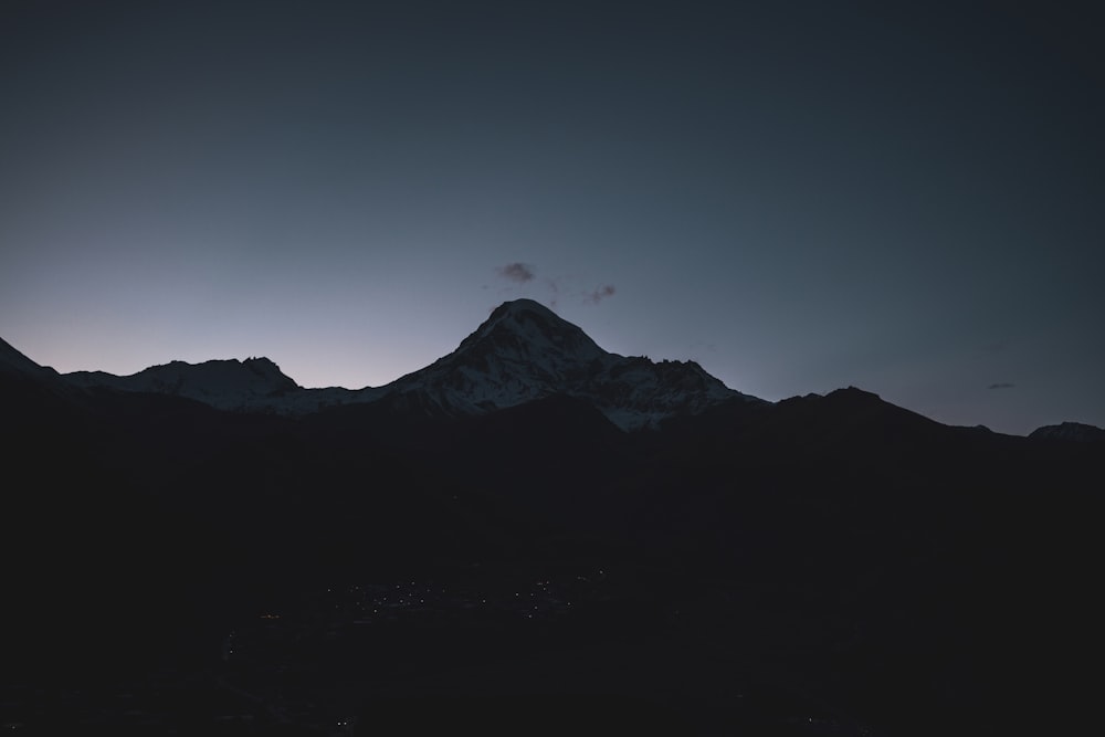 the sun is setting behind a mountain peak