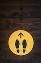 a wooden floor with a yellow sign with a picture of a pair of feet