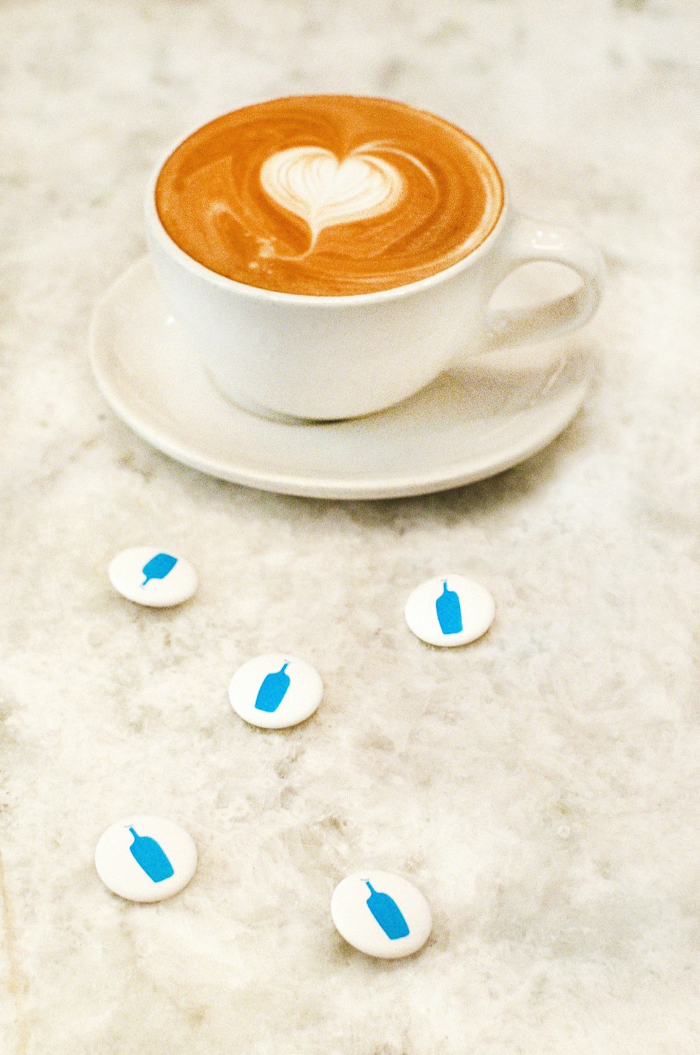 a cup of coffee on a saucer with blue hearts on it