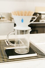 a glass pitcher filled with french fries on top of a stove