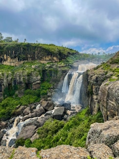 a waterfall in the middle of a lush green valley