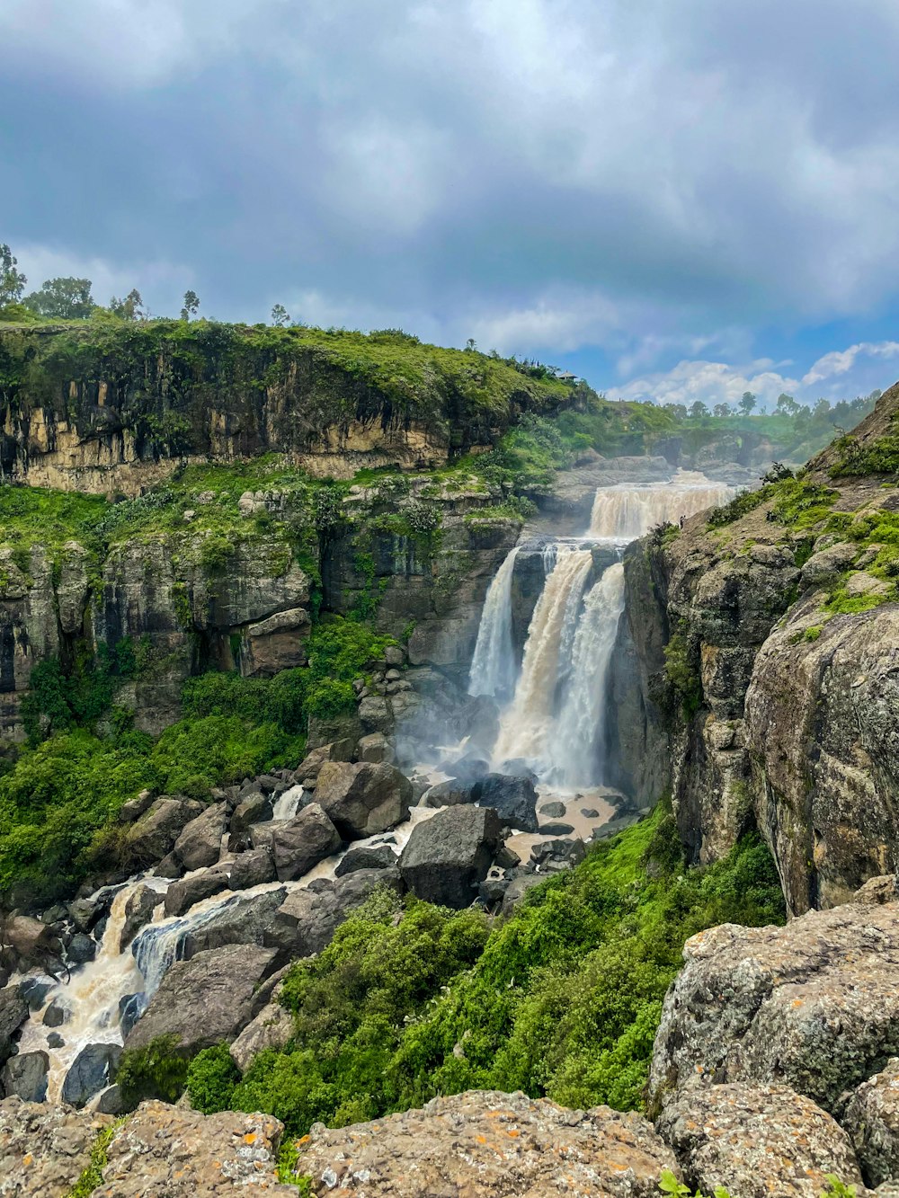 Una cascata nel mezzo di una valle verde e lussureggiante