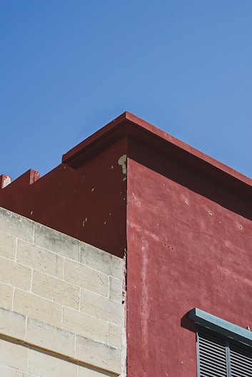 a red building with a clock on the side of it