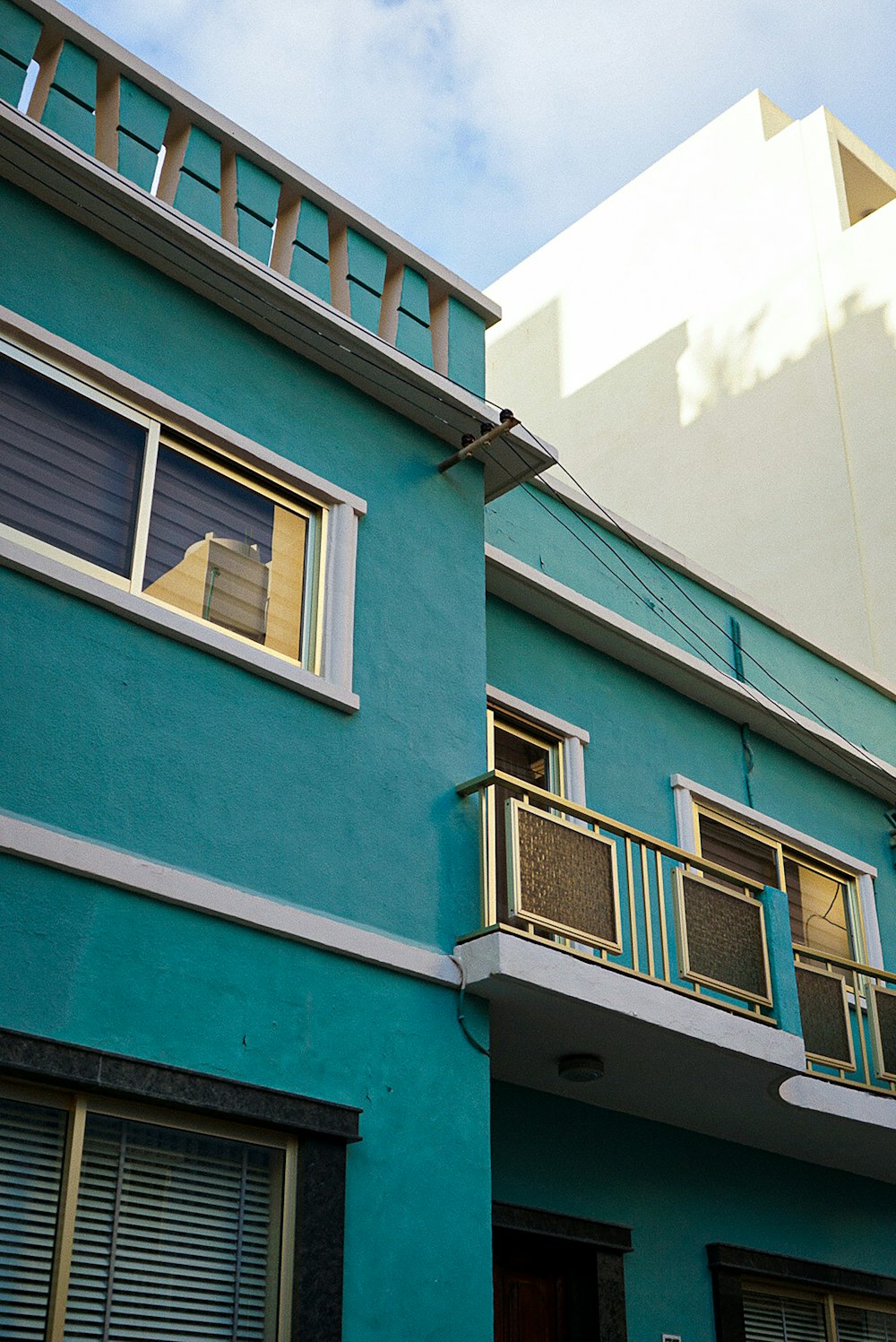 a blue building with two balconies and a balcony