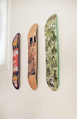 three skateboards mounted to a wall in a room