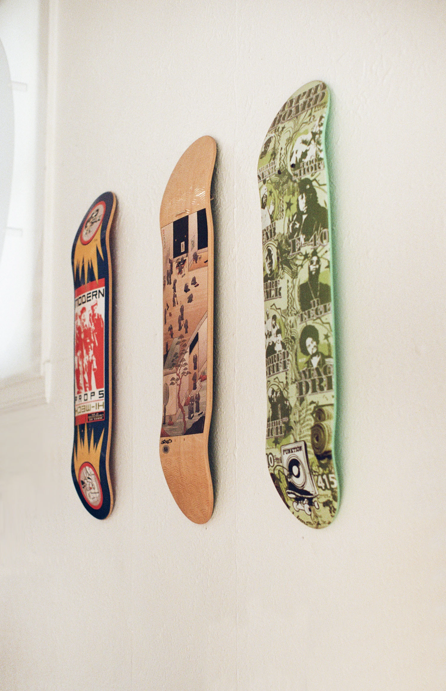 Three decks hung flat on the shop wall above the bench