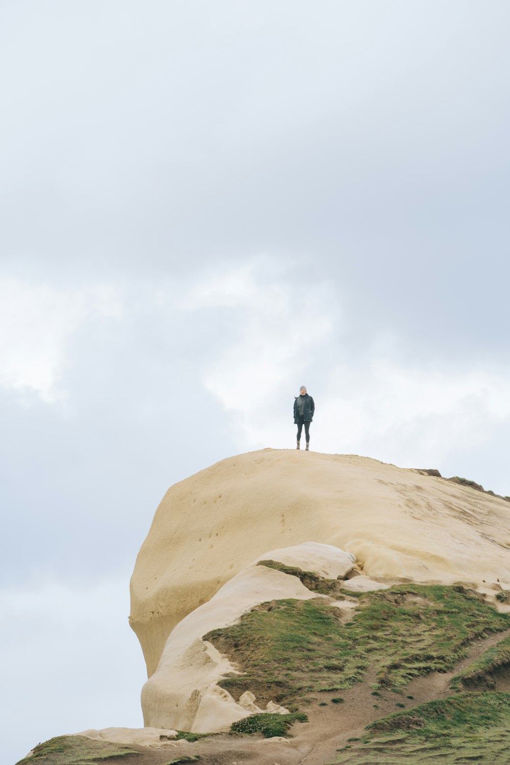 a person standing on top of a sand dune