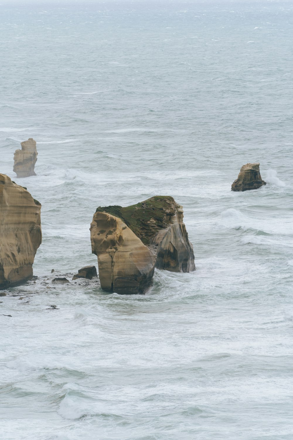 a group of rocks sitting in the middle of a body of water