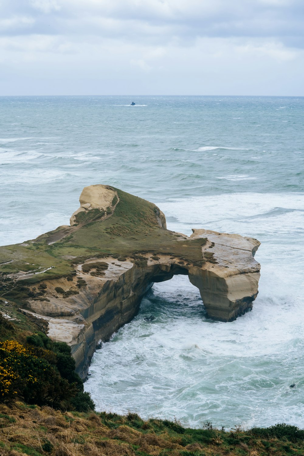 a large rock sticking out of the ocean