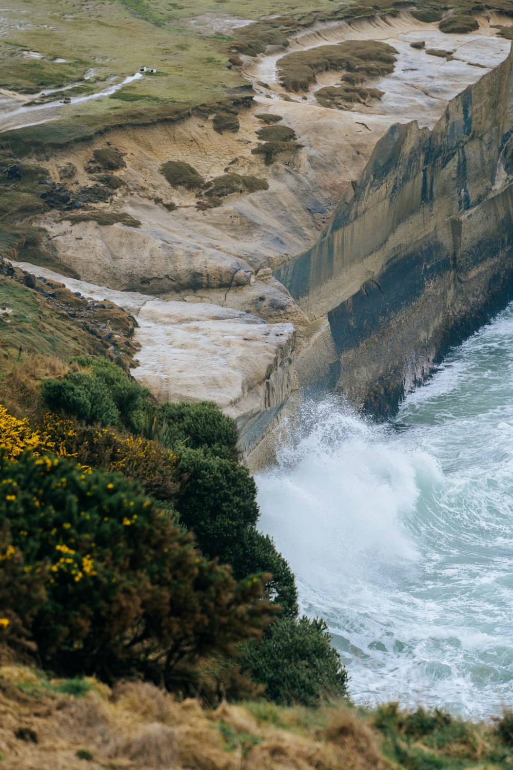 a large body of water next to a rocky cliff