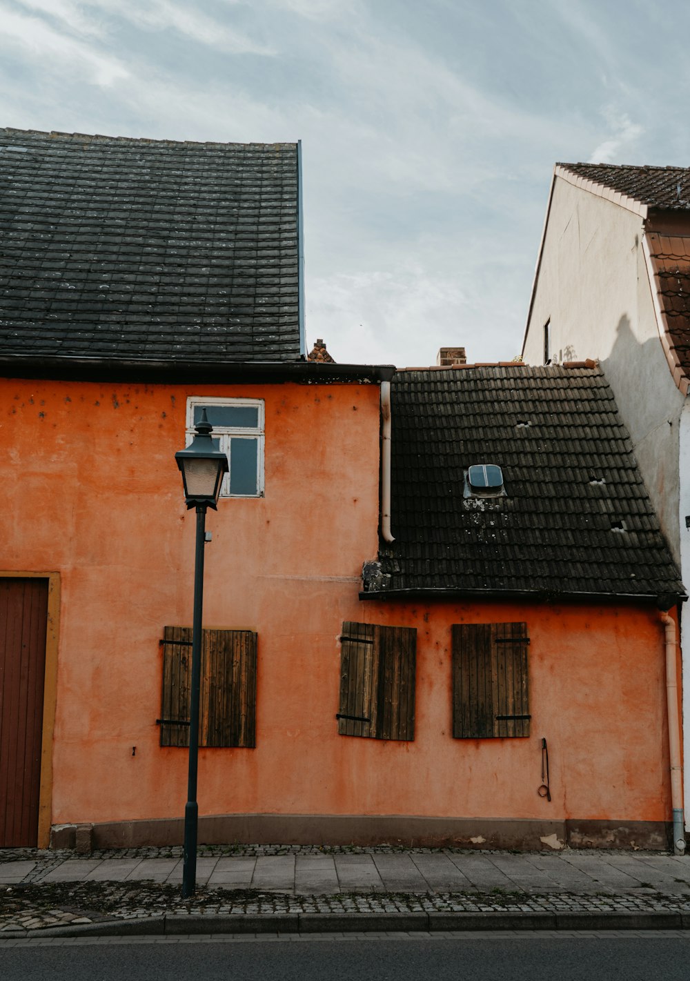 an orange building with shutters and a street light