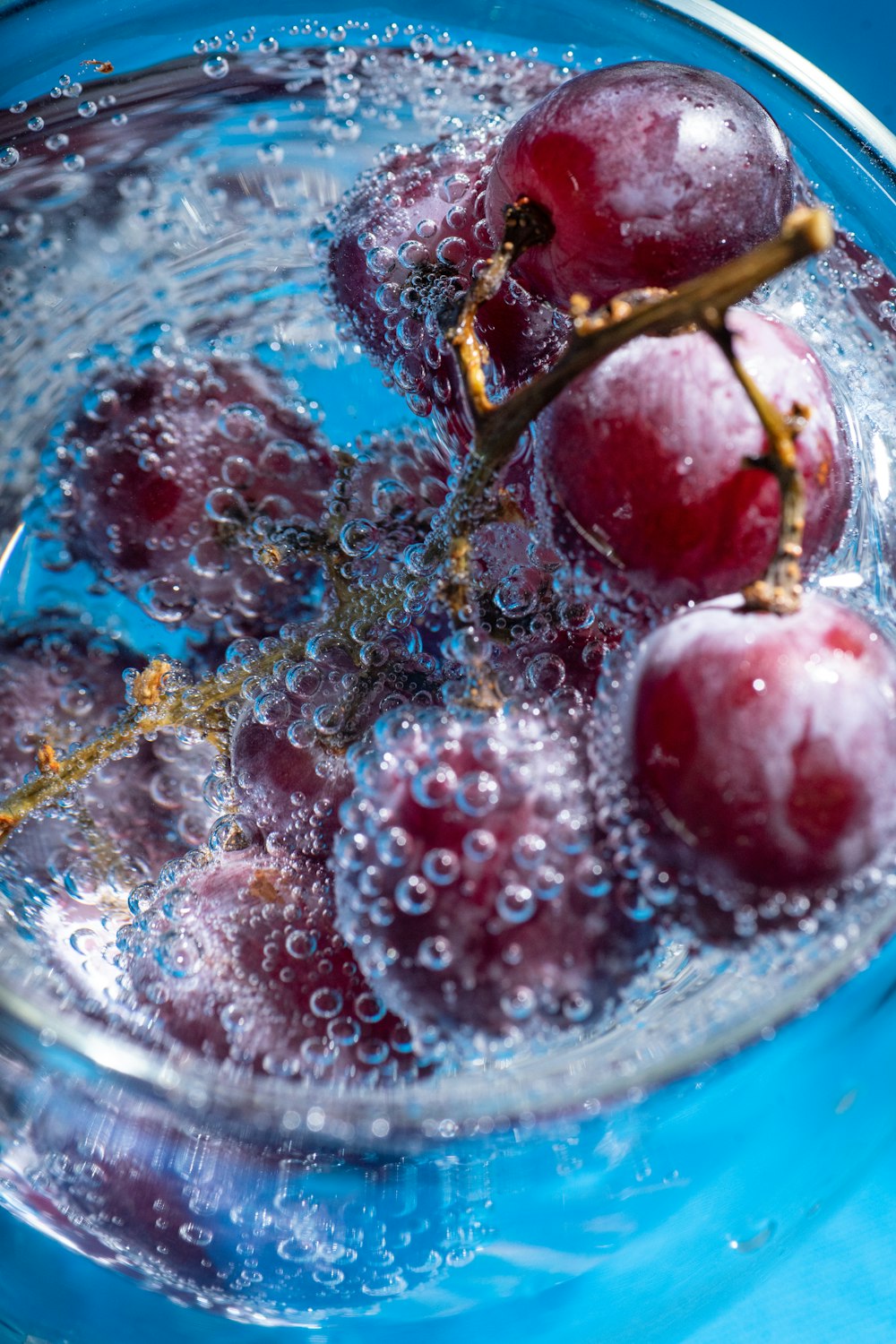 a glass bowl filled with water and cherries