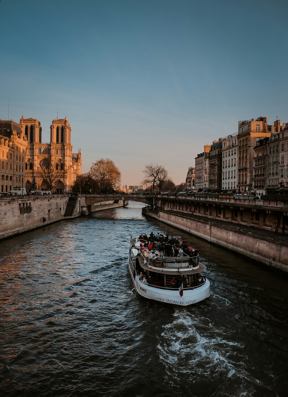 a boat traveling down a river next to tall buildings