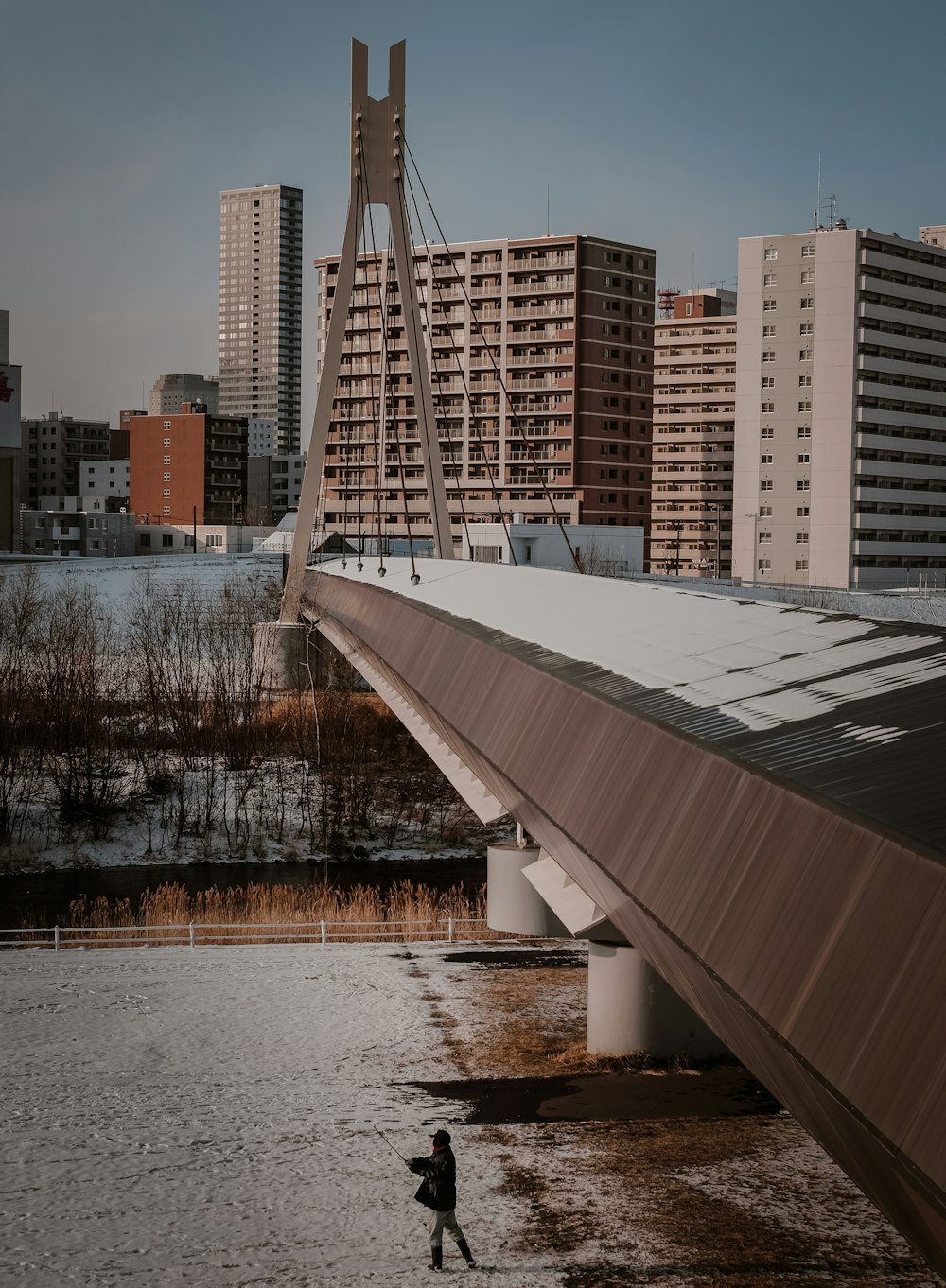 a man walking across a bridge over a body of water