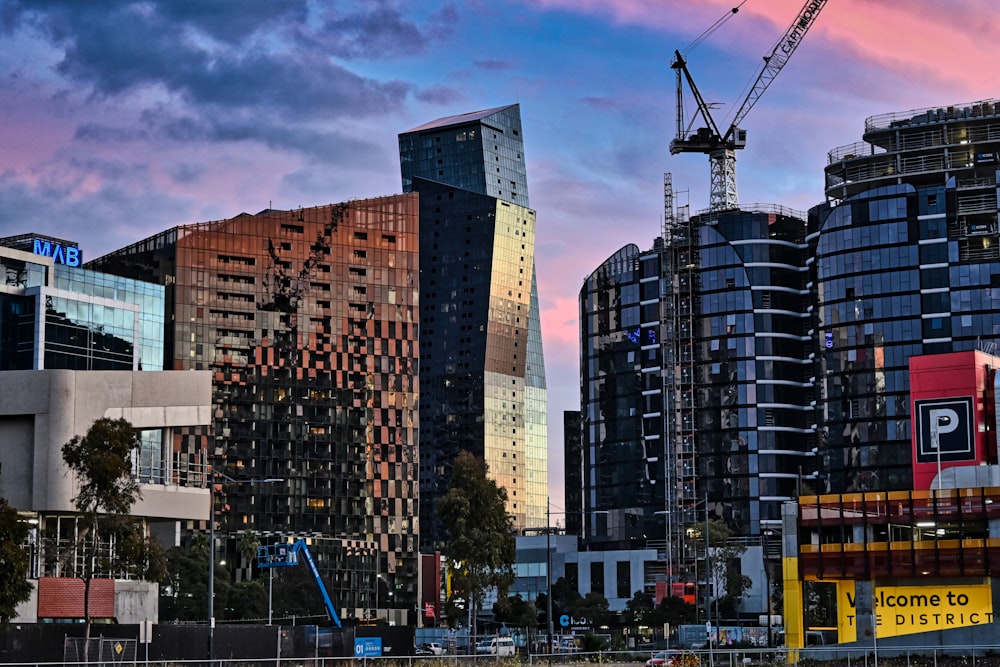 a city with tall buildings and a crane in the sky