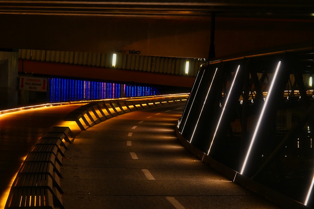 a bench sitting on the side of a road at night