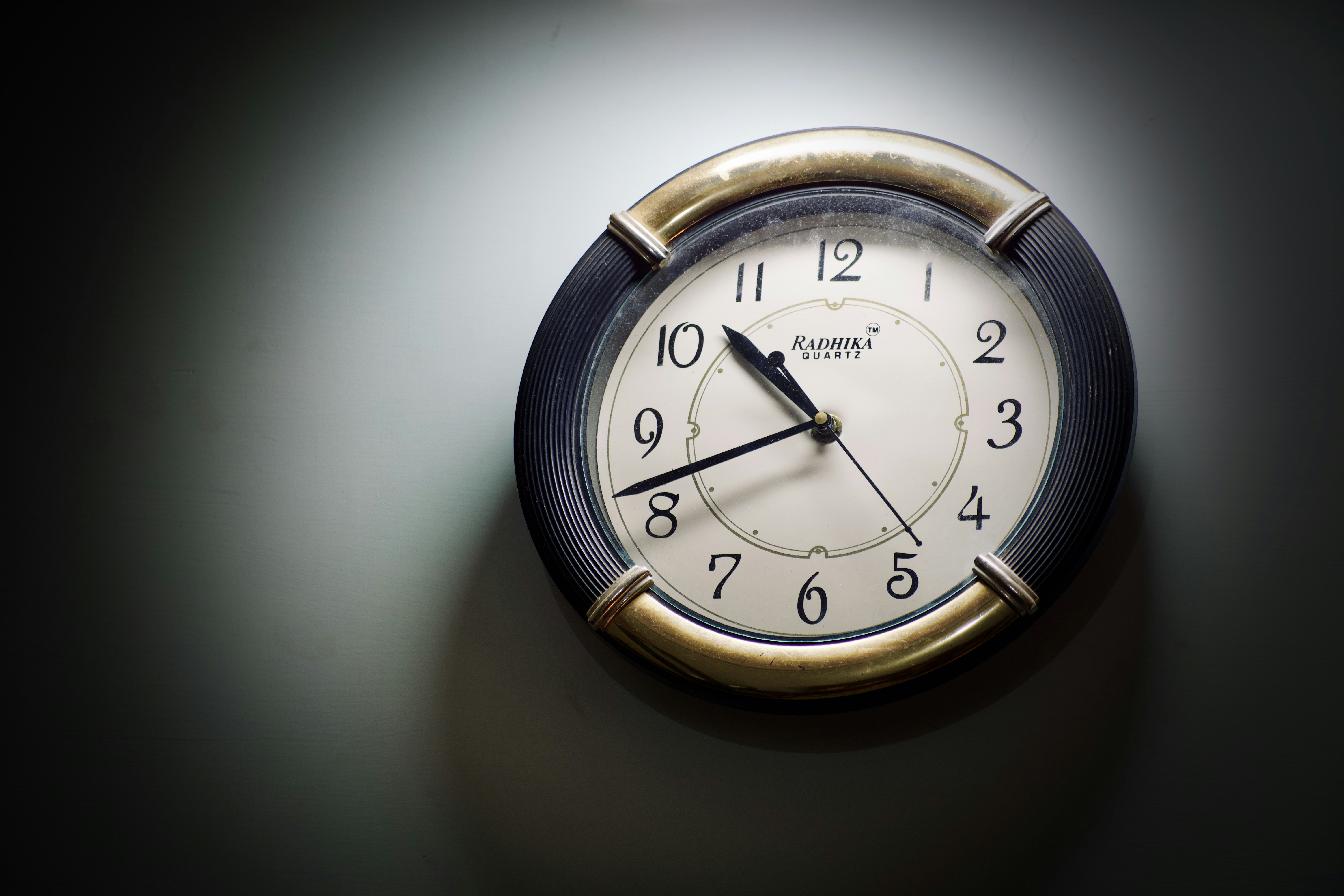 um relógio é mostrado em uma parede no escuro