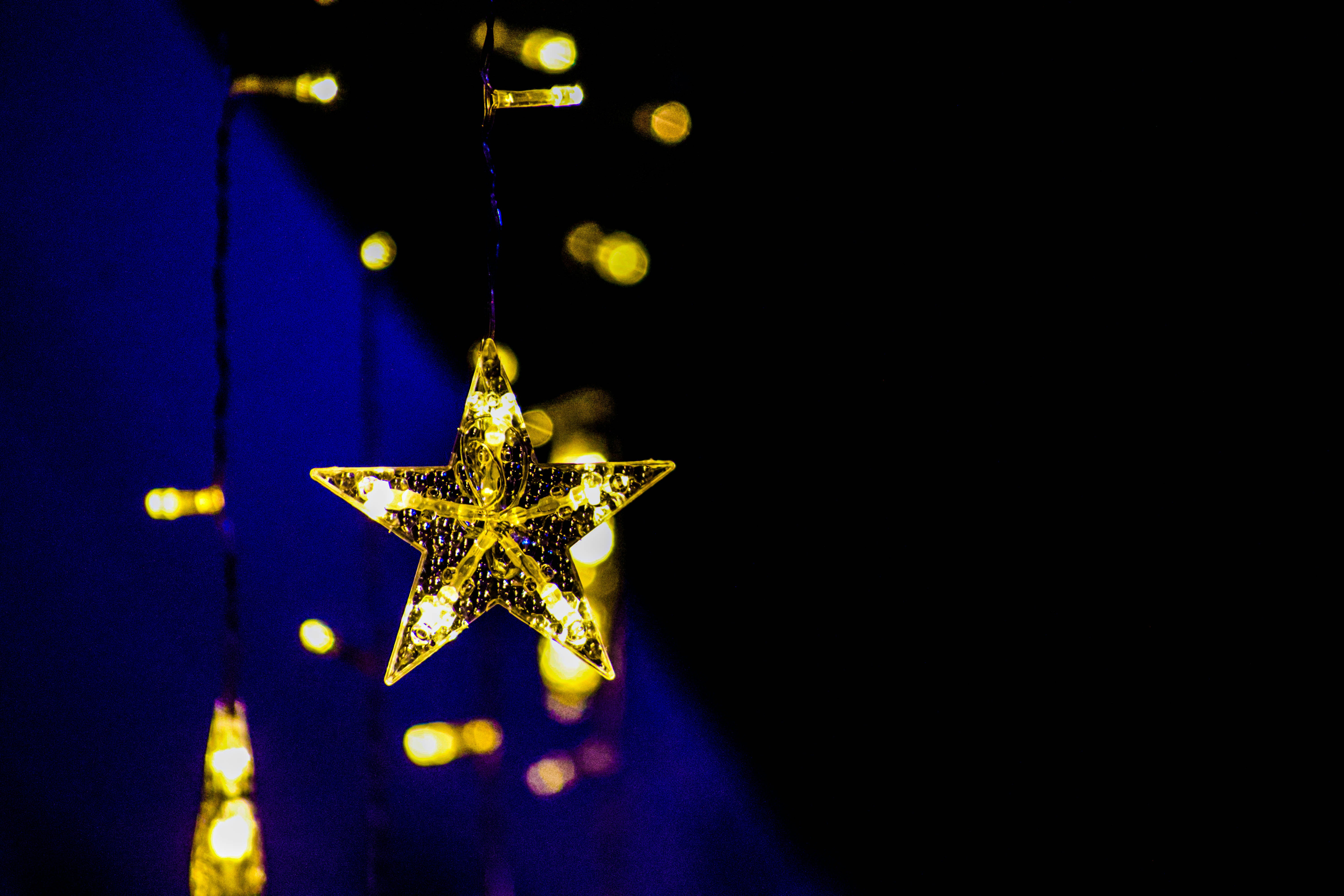 uma estrela iluminada pendurada em uma série de luzes