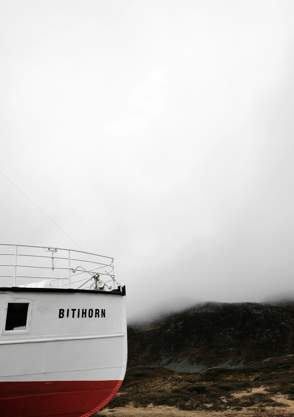 a boat sitting on top of a dry grass field