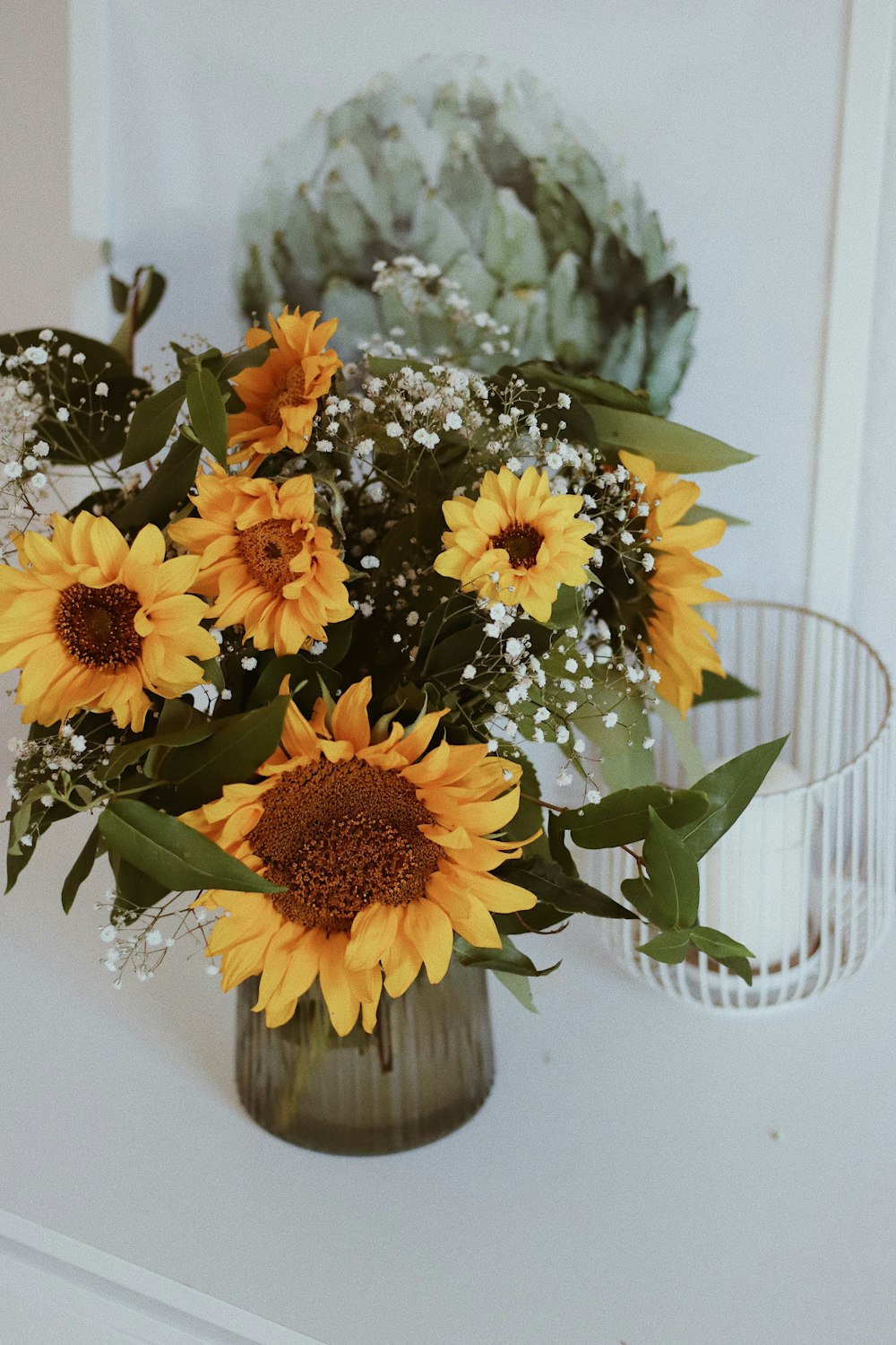 a vase filled with yellow sunflowers on top of a table