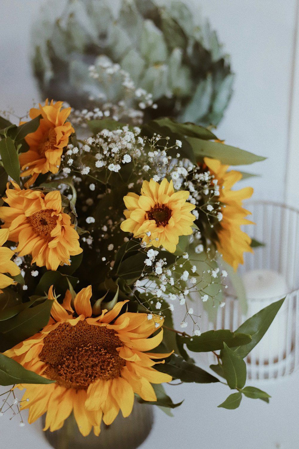 a vase filled with lots of yellow sunflowers