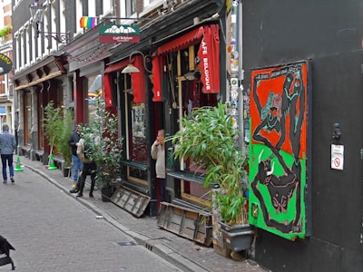 A cozy street-side café with colorful murals and locals chatting over coffee.