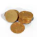 A collection of shiny, gold-colored coins featuring a prominent Bitcoin symbol on each. The coins are stacked and scattered on a white background.