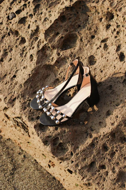 Close-up of elegant women's high heels in violet and black tones on a soft fabric background