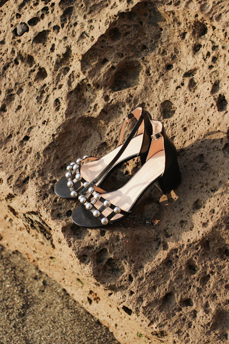 Close-up of elegant women's high heels in violet and black tones on a soft fabric background