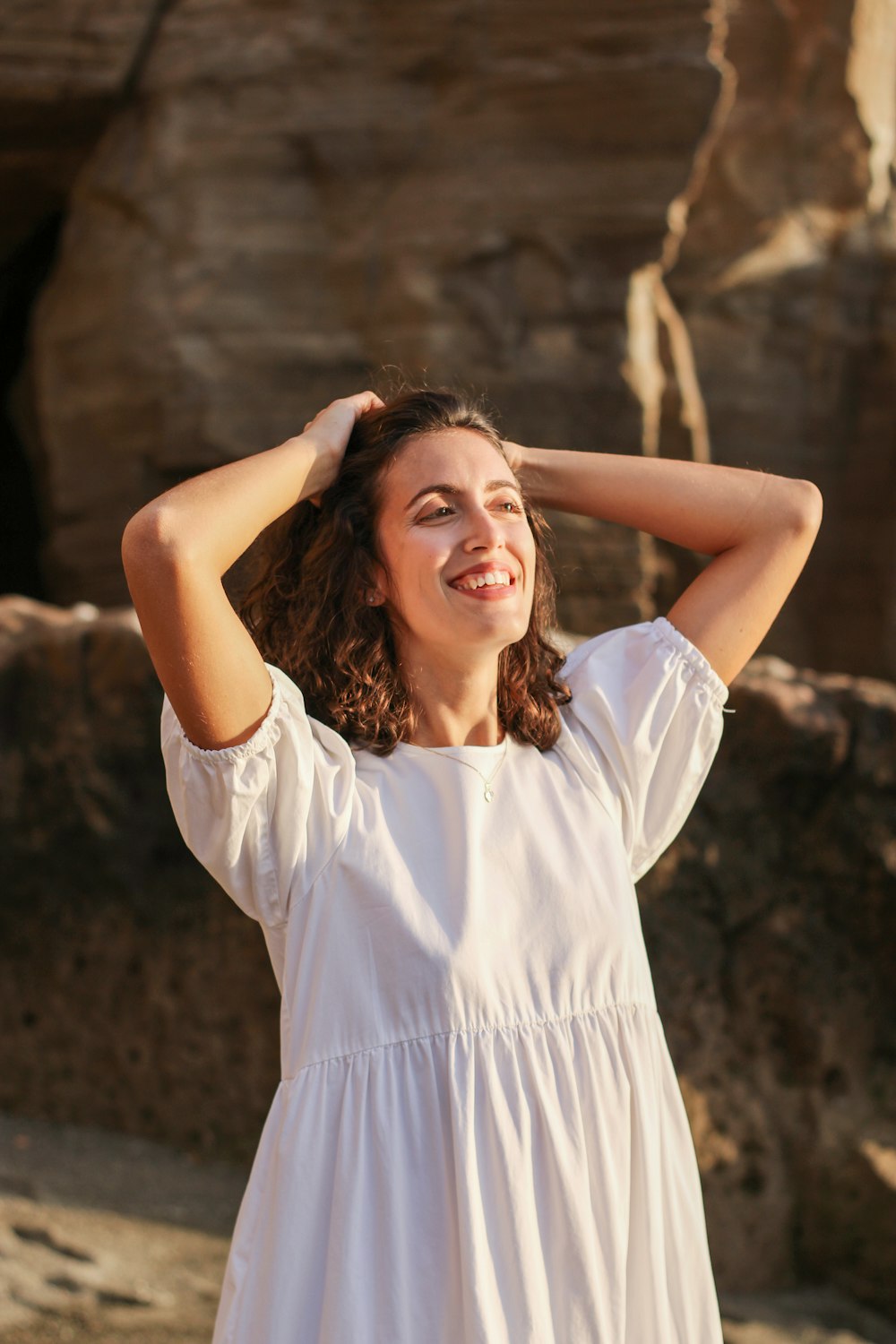 a woman in a white dress standing on a beach