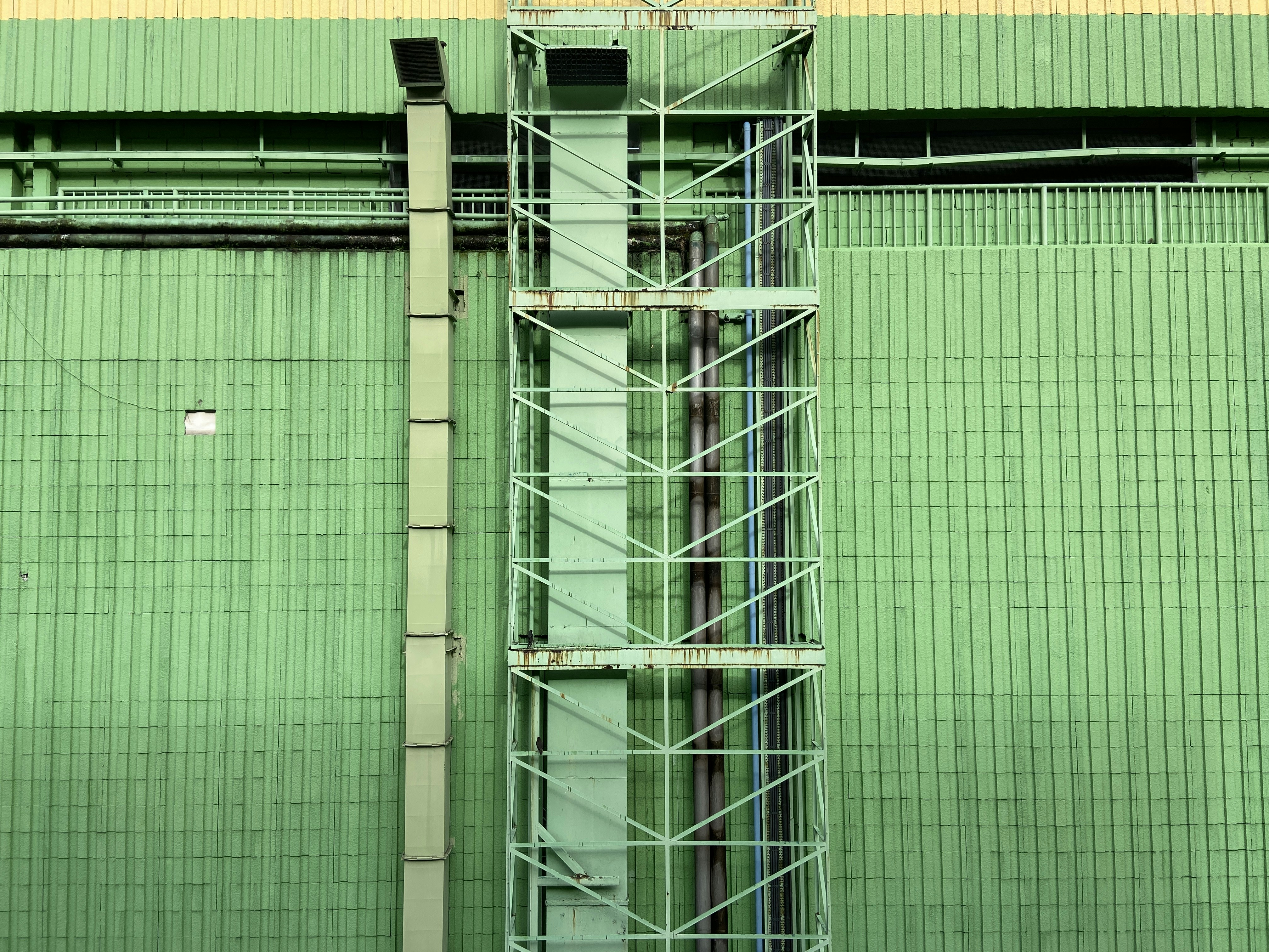 a tall green building with a clock on it's side