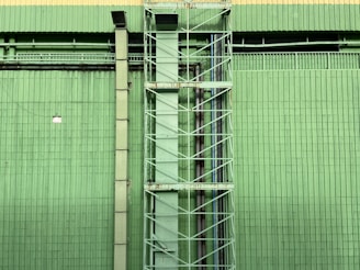 a tall green building with a clock on it's side