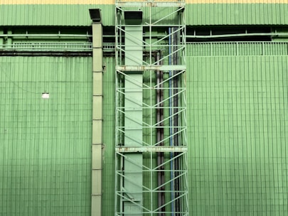 a tall green building with a clock on it's side