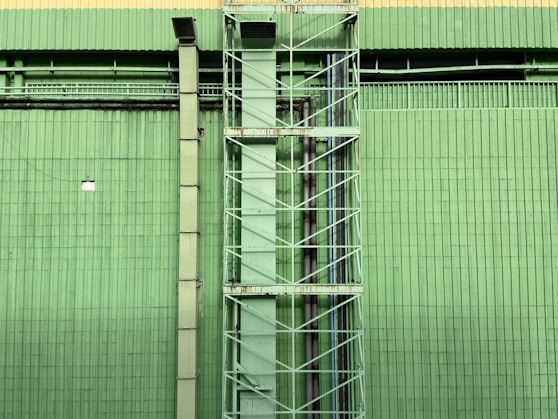 a tall green building with a clock on it's side