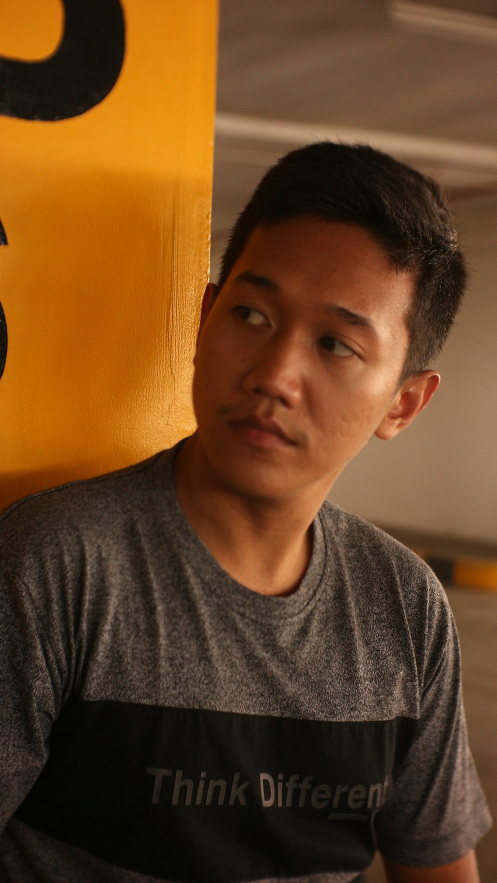 a man standing in front of a yellow sign