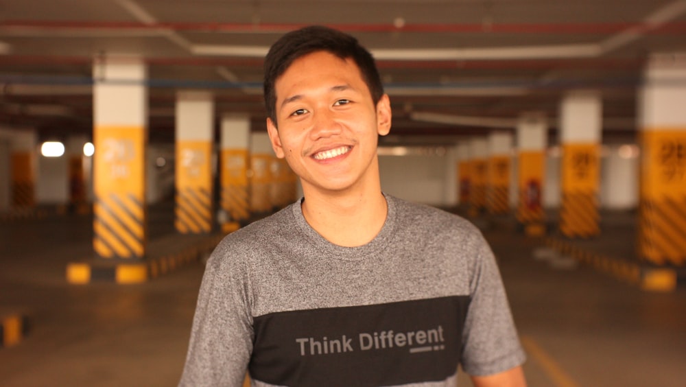 a man standing in a parking garage smiling