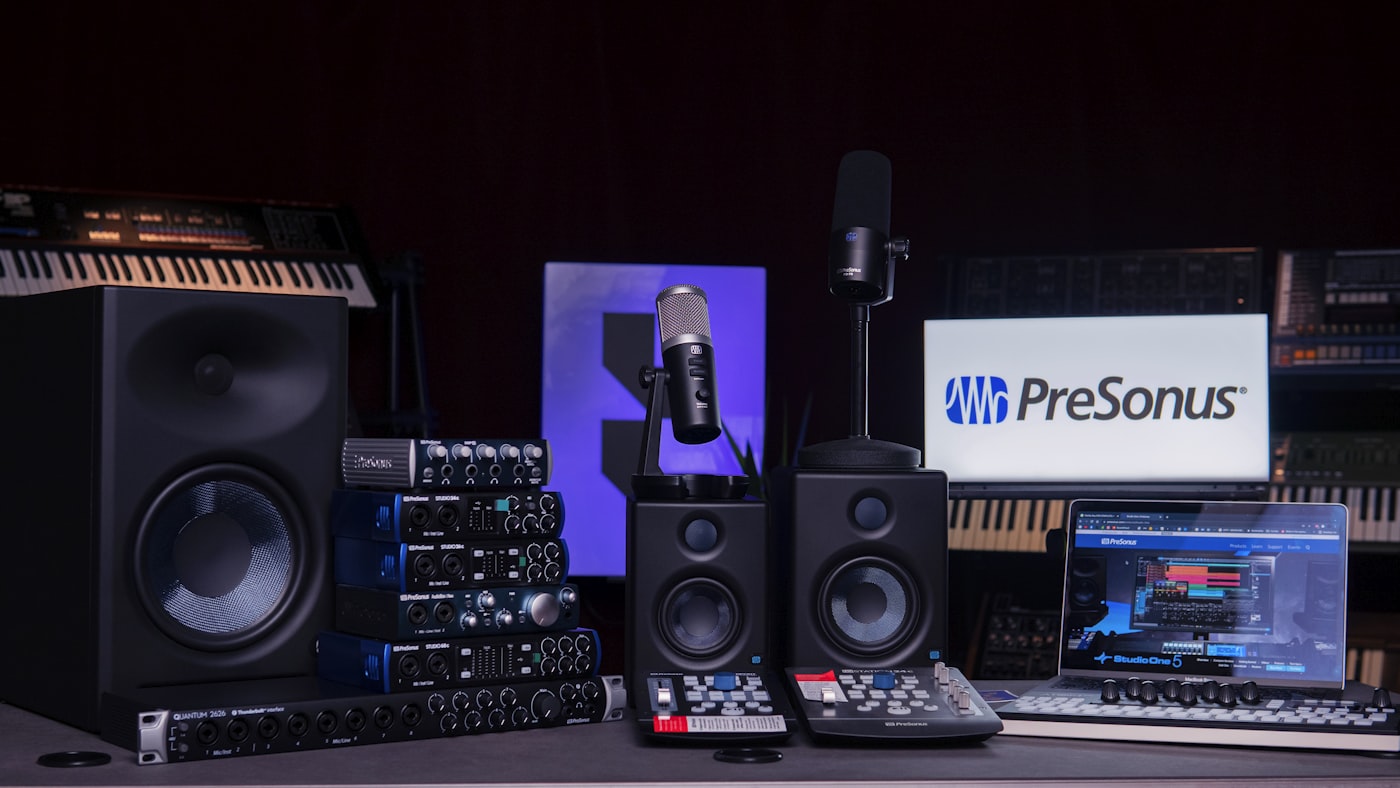 Recording desk with monitor, speakers, and a microphone