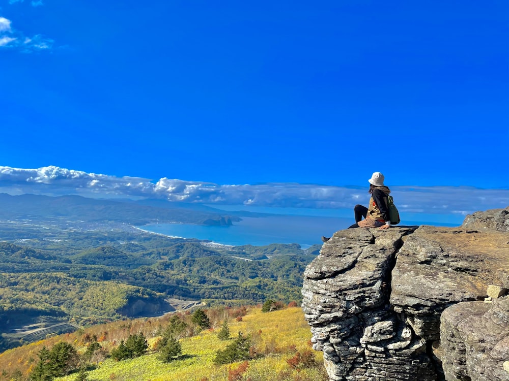 Eine Person, die auf einem großen Felsen sitzt