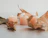 A softly glowing beeswax candle nestled among dried autumn leaves on a dark wooden surface.