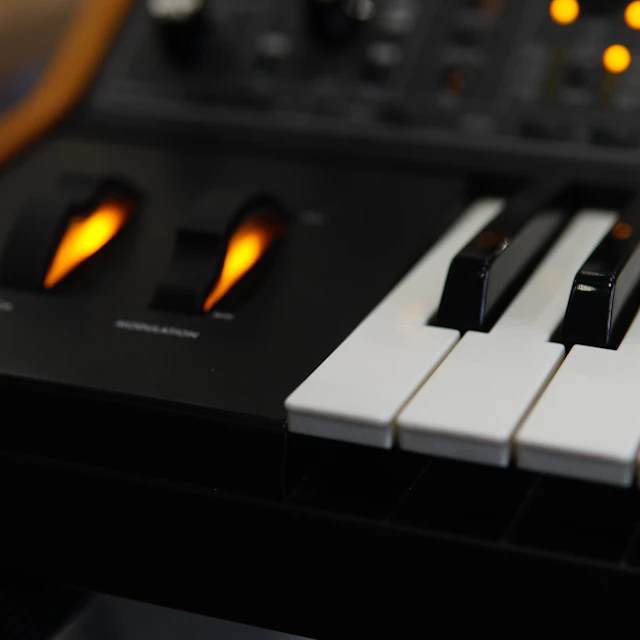 Close-up of a synthesizer control panel covered in knobs