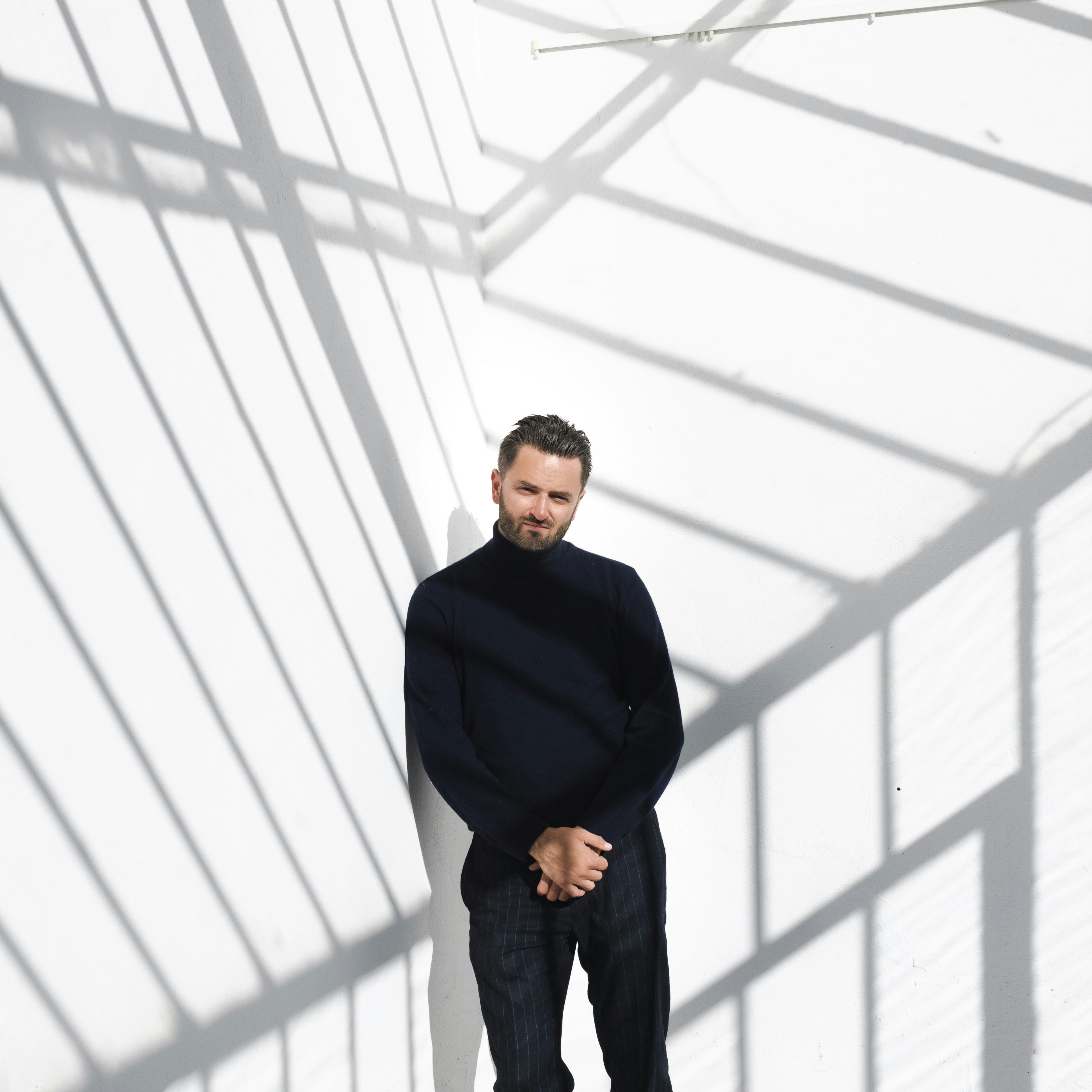 a man standing in front of a white wall