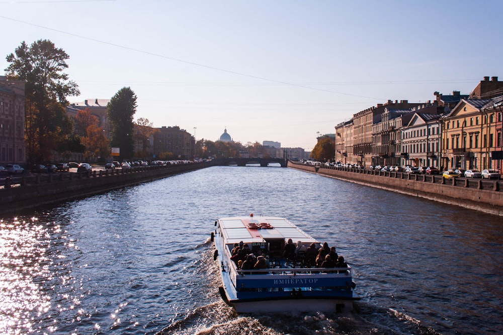 a boat traveling down a river next to tall buildings