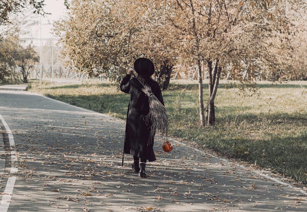 a woman in a black dress is walking down the street