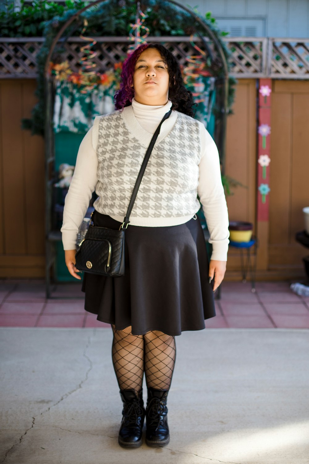 a woman in a white sweater and black skirt