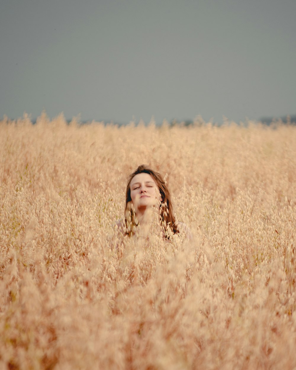 a woman laying in a field of tall grass